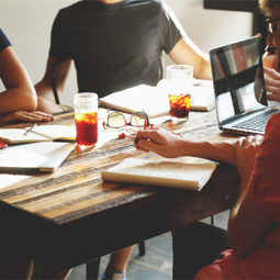 People sat around a table with paperwork and drinks on it News Article